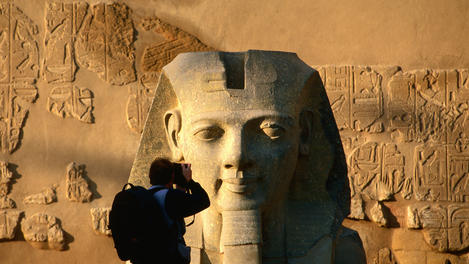 Photographer taking picture of Ramses II statue, Luxor Temple.