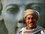 Man in front of Ramses II statue, Luxor Temple, East Bank of Nile River valley.