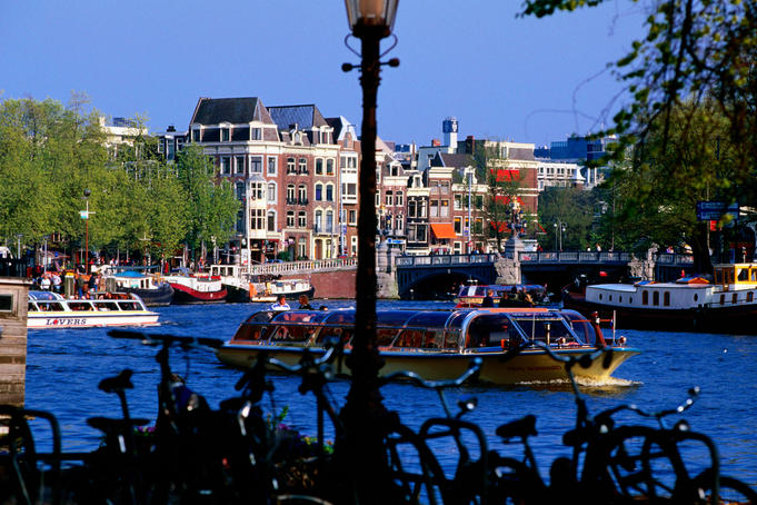 Amstel river sightseeing boats with bicycles in foreground.