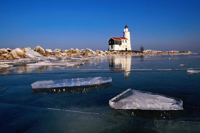 Lighthouse on frozen Ijsselmeer lake.