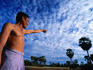 Man points out sugar palm grove near Angkor Wat.