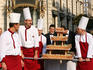 Men carrying cake at wedding.