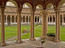 Cloisters attached to San Zeno Maggiore church with both rounded Romanesque and Gothic pointed arches.