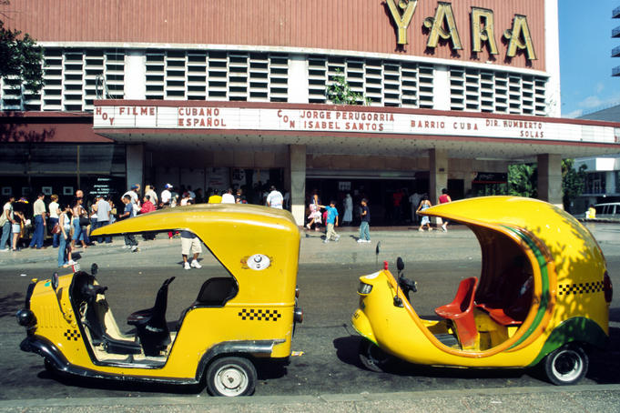 Coco taxis outside the cinema in Vedado.