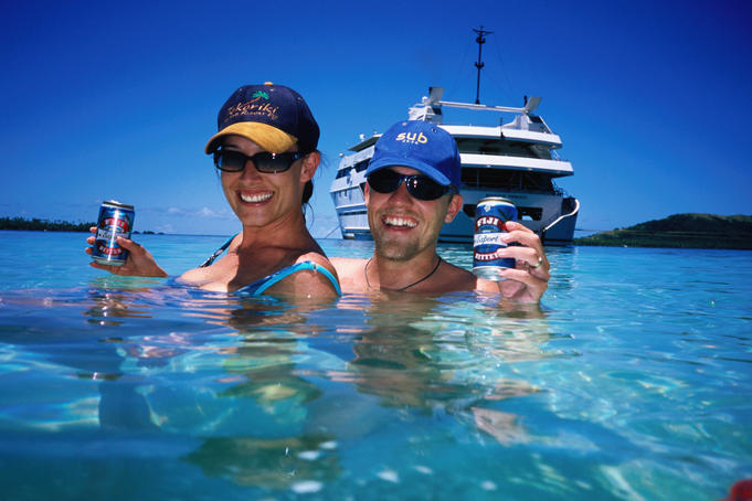 Couple enjoying beer in lagoon, Blue Lagoon cruise, Nanuya Lailai Island.