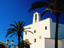 Sant Josep de Sa Talaia, whitewashed village church, palms in foreground.