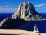 Near Sant Josep de Sa Talaia, girl on rock looking at offshore isle of Es Vedra.