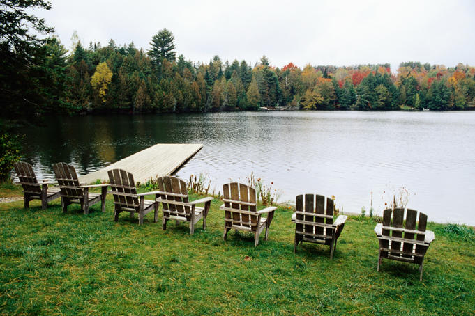 Adirondack chairs in row by lake, Northeast Kingdom.