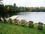 Adirondack chairs in row by lake, Northeast Kingdom.