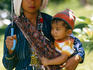 T'boli mother and son in the shade of an umbrella.