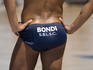 A 'Bondi' Surf Life Saver watching Surf Life Savings competitions at Bondi Beach.