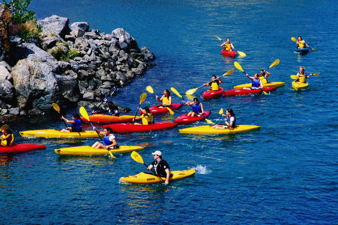 People kayaking in red and yellow kayaks.