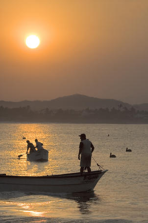 Silhouette of fisherman and boats.