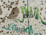 Bar advertisement on a wall damaged by gunfire.