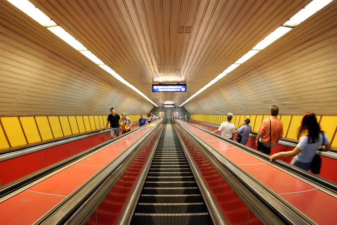 Escalators leading down to underground metro line at Klinikak station, Pest.