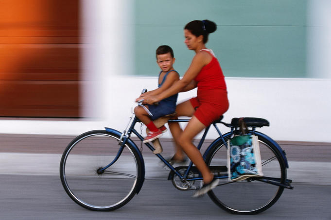 Woman and small boy riding a bicycle.
