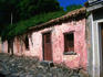 Exterior of historic and weathered pink house.