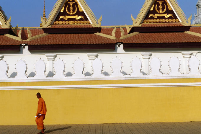 Lone monk passes walls of Royal Palace.