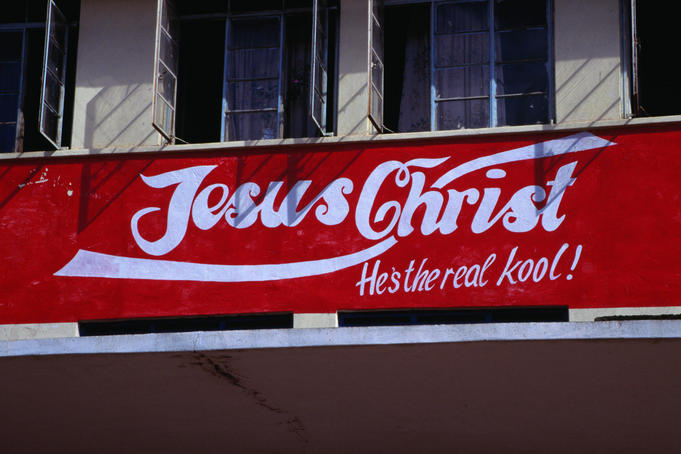 A sign declaring someone's feelings for Jesus Christ, painted on a building in the style of the Coca-Cola logo