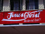 A sign declaring someone's feelings for Jesus Christ, painted on a building in the style of the Coca-Cola logo