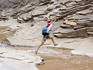 Hiker leaps across a creek, North canyon, Colorado River.