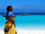 Woman in kanga on beach.