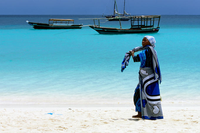 Woman wearing kanga on beach.