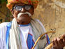 Portrait of Rajasthani man with turban playing traditional Indian stringed instrument, Sarangi.