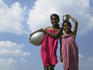 Low angle view of Indian girls carrying water jars.