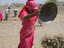 Woman emptying dish of earth to build a road in the desert, between Jodhpur and Jaisalmer.