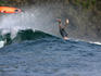 Surfer falling over back of wave.