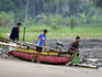 Young fishermen launching boat.