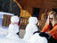 Mother and daughter building snowmen outside chalet.