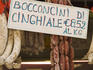 Salami's and sausages hang from window in local deli, Castiglione del Lago.