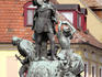 Statue in Dobo Istvan Ter commemorating 1552 Turkish siege, with Old Town buildings in background.