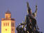 Statue in Dobo Istvan Ter commemorating 1552 Turkish siege with floodlit tower in background.