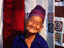 Portrait of Hmong woman at stall with hand made textiles behind.