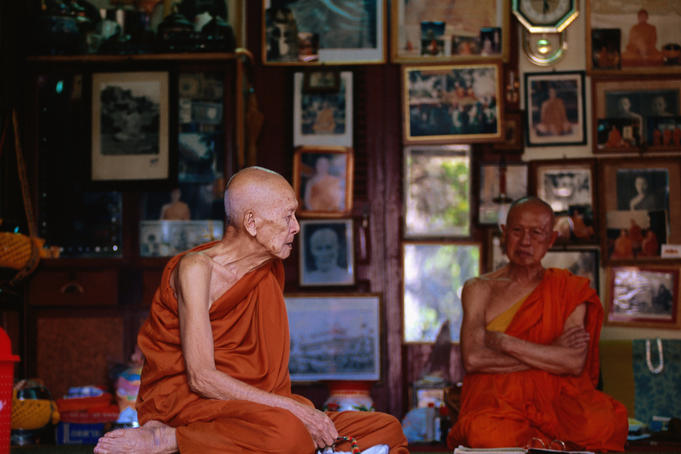 Old monk sitting with abbot of Wat Saen in temple library.