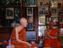 Old monk sitting with abbot of Wat Saen in temple library.