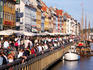 People at outdoor restaurants and young people along the canal, Nyhavn.