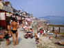Crowed beach lined with bathing boxes.