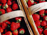 Strawberries in their characteristic baskets sold on street stalls.