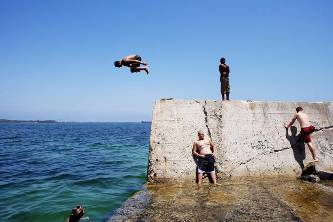 Young people jumping off wall at The Suction, Botany Bay.