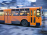 bus speeding through Central Belgrade at dusk.