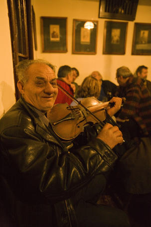 Gypsy plays fiddle at traditional Balkan tavern named '?', one of the oldest bars in Belgrade.