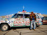Artist posing in front of folk art creation Salvation Mountain.