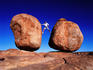 Man balancing between giant boulders.