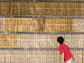 Young boy reading inscriptions on wall of wooden tablets.