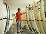 Man browsing through new and second-hand surf boards.