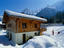 Children playing outside chalet with mountains in background, Les Houches.
